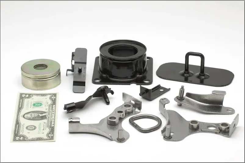 Stamped brackets and formed metal housings shown with a banknote for scale
