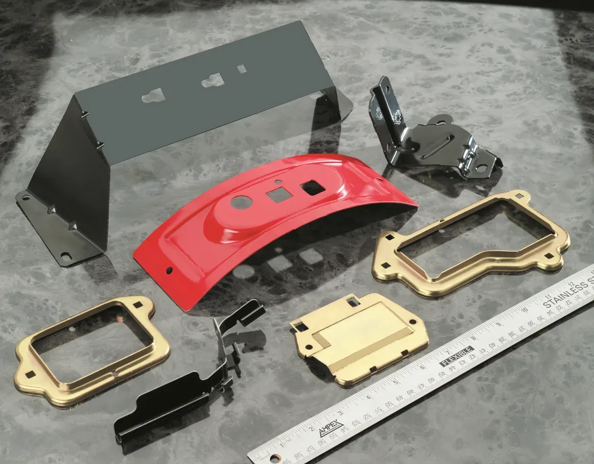 Painted and plated formed metal brackets and frames shown beside a steel ruler